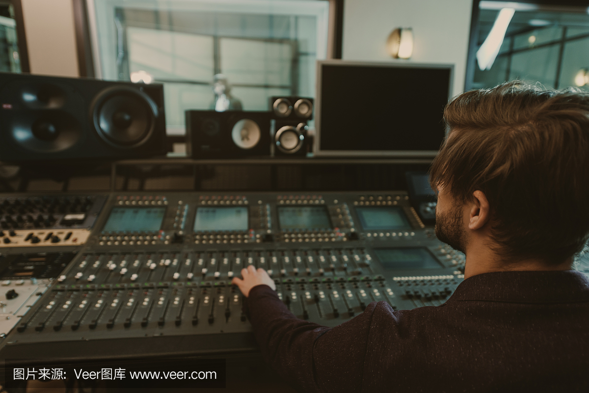 年輕英俊的聲音制作人在錄音棚工作